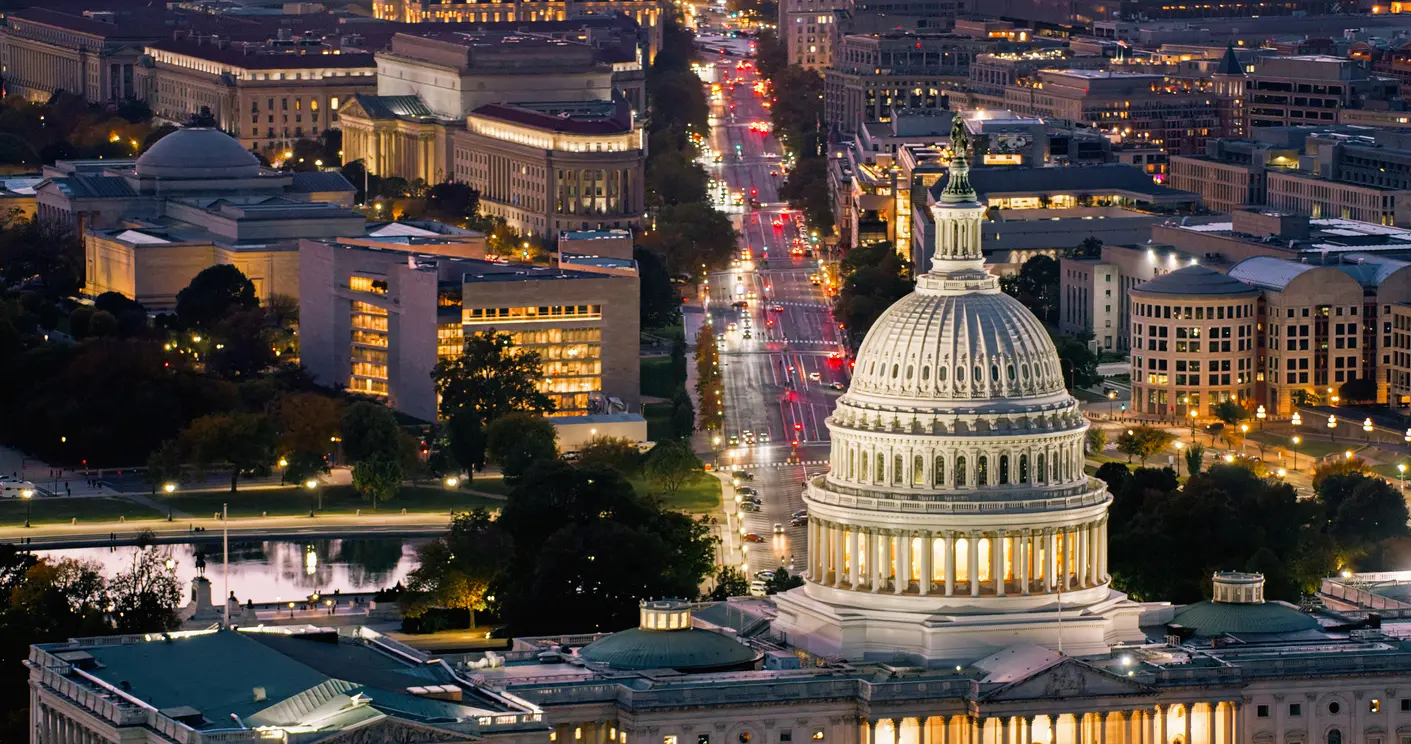 Aerial View Over Capitol Building Towards Government Offices on Pennsylvania Avenue High angle helicopter shot of the Capitol Building in Washington, D.C. at twilight on a clear evening in Fall, with the Federal Trade Commission Headquarters on Pennsylvania Avenue beyond.